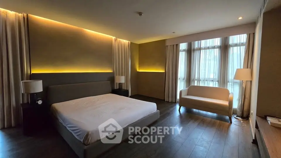Luxurious bedroom with modern lighting and large windows in a high-end apartment.