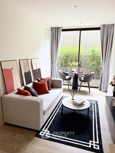 Modern living room with stylish decor and large window overlooking greenery, perfect for relaxation and entertaining.