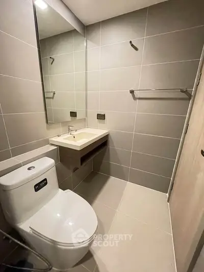 Modern bathroom with sleek fixtures and large mirror in a contemporary apartment.