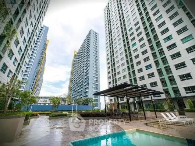 Modern high-rise residential buildings with pool and outdoor seating area.