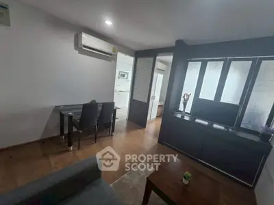 Modern living room with dining area and kitchen in open layout apartment.