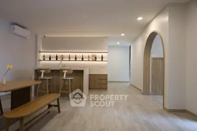 Modern open-plan living space with stylish bar and wooden accents