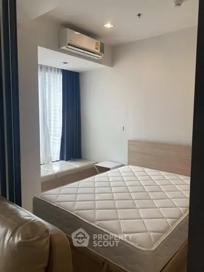 Modern bedroom with large window and air conditioning in a stylish apartment.
