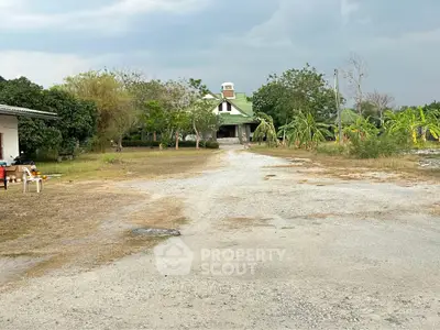 Charming countryside property with spacious driveway and lush greenery, perfect for serene living.