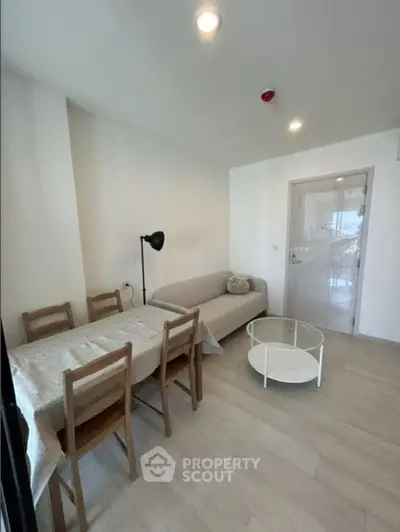 Modern living room with cozy sofa and dining area in a bright apartment.