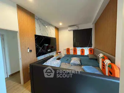 Modern bedroom with stylish decor and large TV, featuring unique wall design and cozy atmosphere.