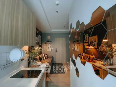 Modern kitchen with stylish hexagonal mirrors and cozy living area in open layout apartment.