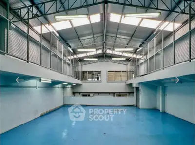 Spacious industrial-style warehouse with high ceilings and ample natural light.