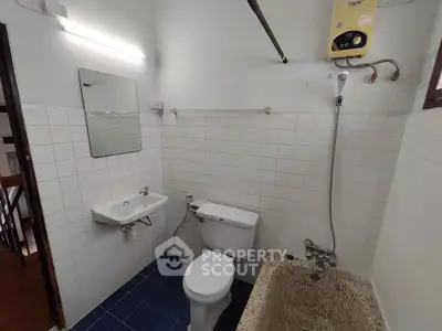 Compact bathroom with white tiles, bathtub, and modern fixtures in a cozy home.