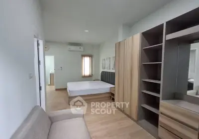 Modern bedroom with wooden furniture and neutral tones, featuring a cozy bed and ample storage space.