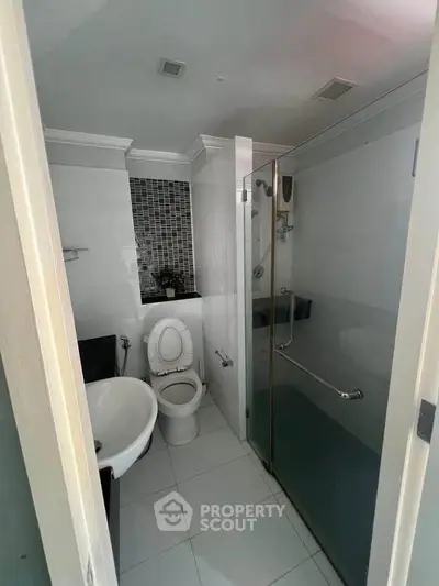 Modern bathroom with glass shower and sleek tile design, perfect for urban living.