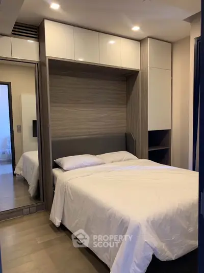 Modern bedroom with sleek design and ample storage in a stylish apartment.