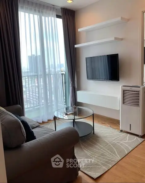 Modern living room with city view, cozy sofa, and wall-mounted TV in a high-rise apartment.