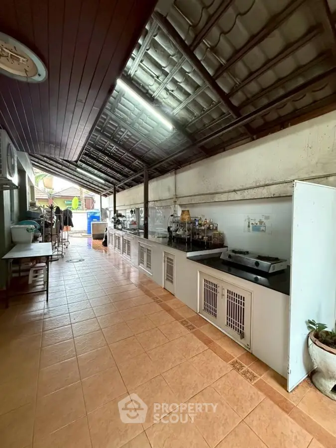 Spacious open-layout kitchen with tiled flooring and ample counter space.