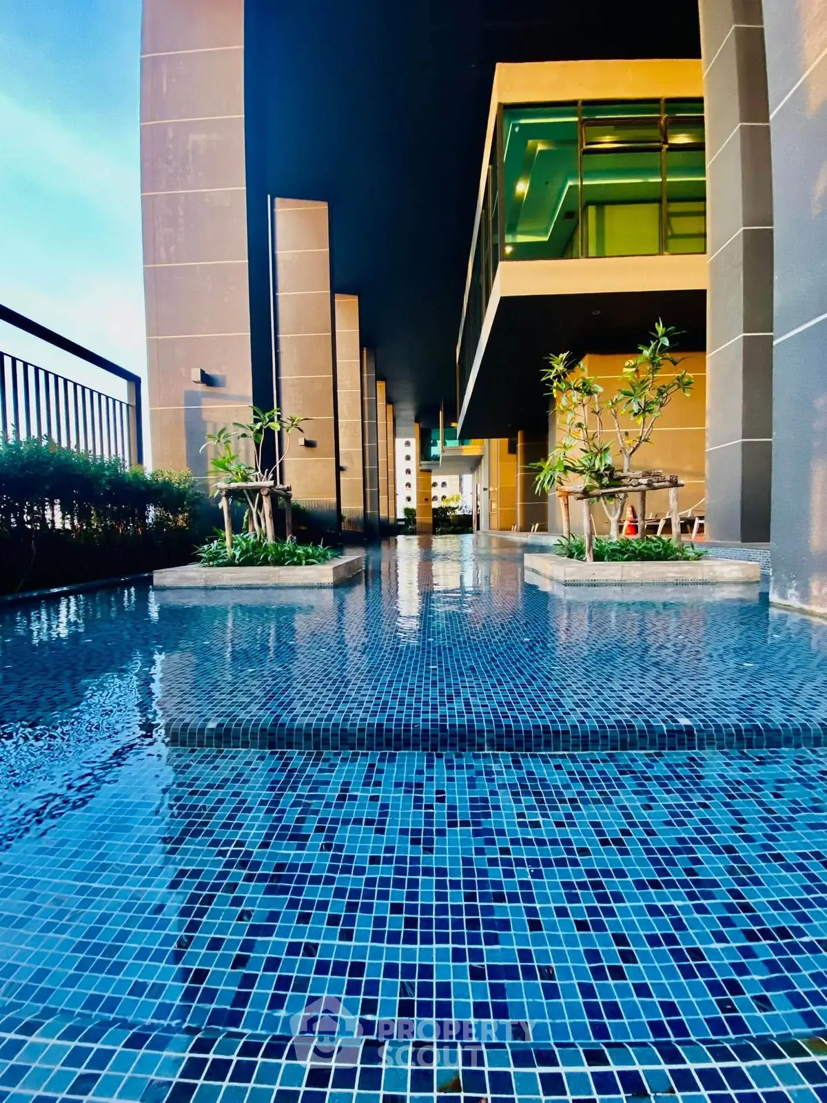 Luxurious modern building exterior with stunning poolside view and elegant architectural design.