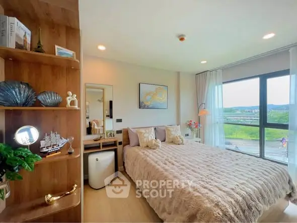 Cozy bedroom with large window and scenic view, featuring elegant decor and plush bedding.