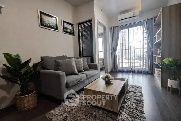 Modern living room with cozy sofa, stylish decor, and large window for natural light.