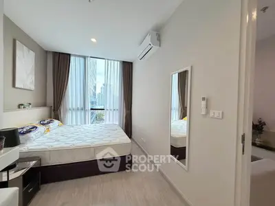 Modern bedroom with large window and city view, featuring a comfortable bed and stylish decor.