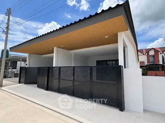 Modern single-story house with sleek black fence and contemporary design.
