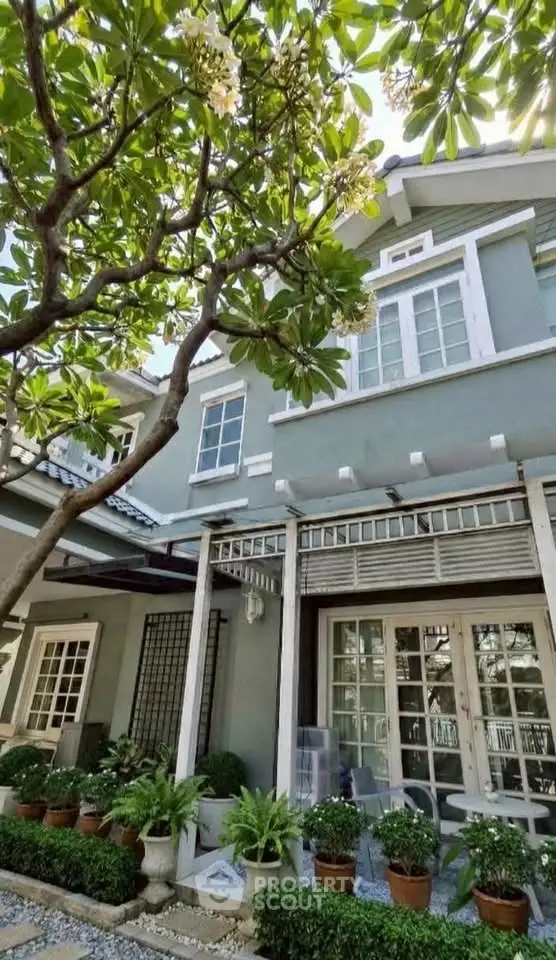 Charming two-story house with lush garden and elegant French doors