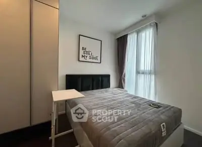 Cozy bedroom with modern decor and large window for natural light