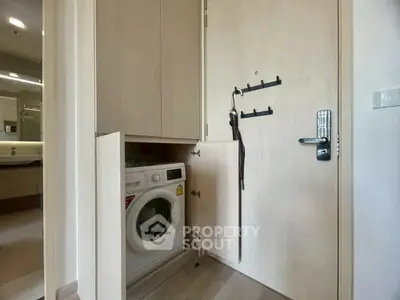 Compact laundry area with built-in washing machine in modern apartment
