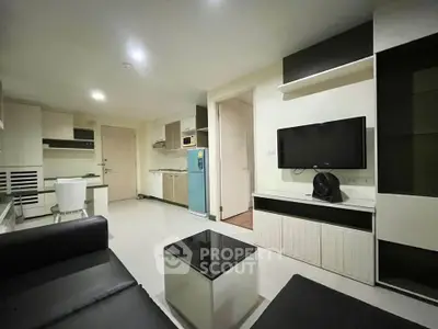 Modern living room with sleek furniture and integrated kitchen in open layout apartment.