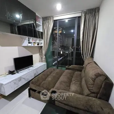 Modern living room with plush sofa and city view through large windows.