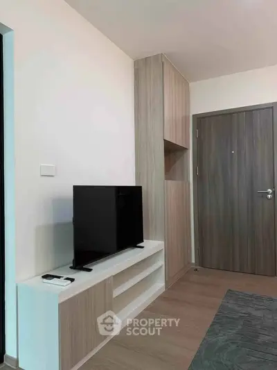 Modern living room with sleek TV stand and wooden cabinetry, perfect for contemporary living.