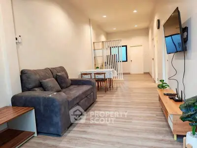 Modern living room with sleek furniture and wall-mounted TV, perfect for relaxation.