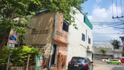 Charming urban corner building with lush greenery and street view