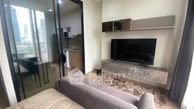 Modern living room with sleek TV unit and city view, adjacent to compact kitchen.