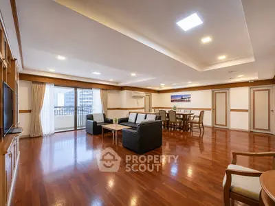 Spacious living room with wooden flooring and modern furniture in a luxury apartment.