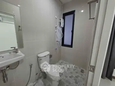 Modern bathroom with sleek fixtures and a window for natural light.