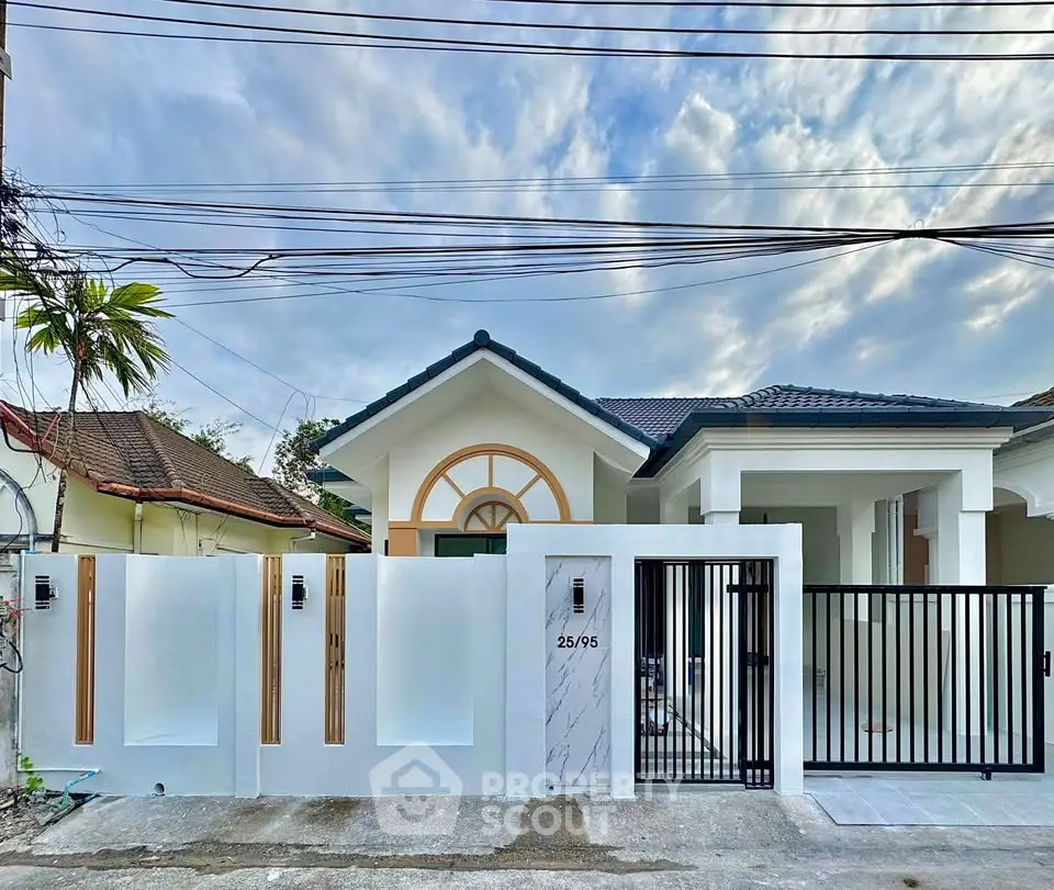 Charming modern house with stylish gate and elegant facade under a picturesque sky.