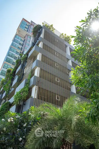 Modern residential building with lush greenery and unique architectural design.
