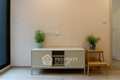 Modern minimalist living room with sleek cabinet and potted plants