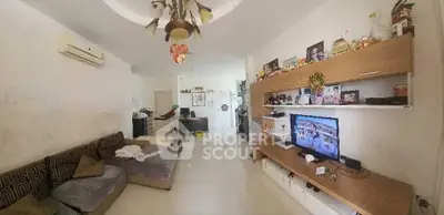 Spacious living room with modern decor and entertainment center, perfect for family gatherings.