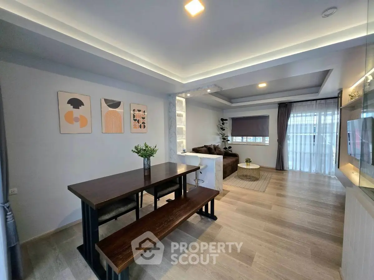 Spacious modern living room with stylish dining area and cozy seating, perfect for family gatherings.