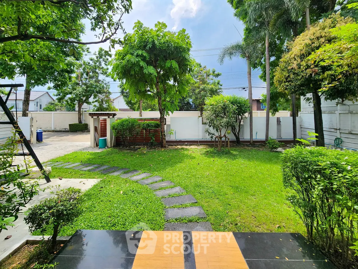 Beautiful garden with lush greenery and stone pathway in a serene residential area.