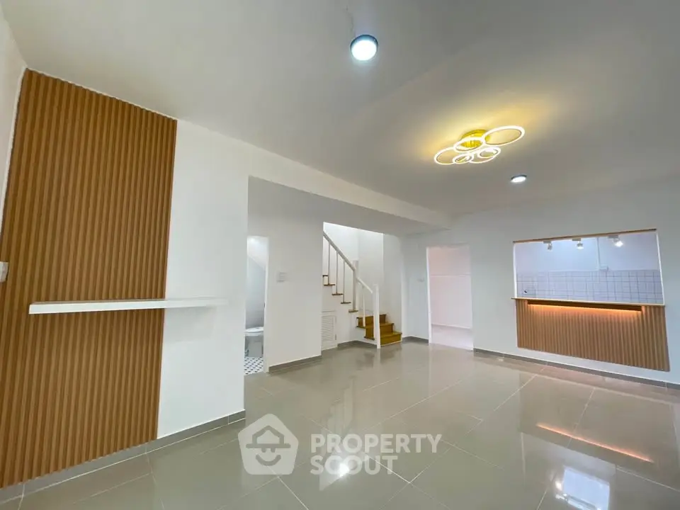 Modern open-plan living area with stylish lighting and sleek tile flooring