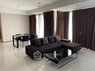 Spacious modern living room with sleek furniture and large windows.