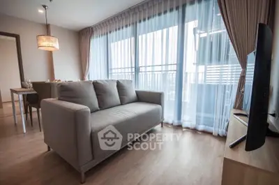 Modern living room with large windows and stylish furniture in a cozy apartment.
