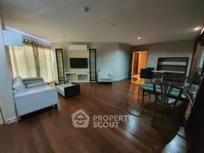 Spacious living room with wooden flooring and modern furniture in a cozy apartment.