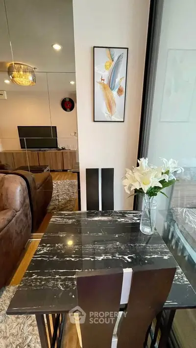 Stylish dining area with marble table and elegant decor in modern apartment.