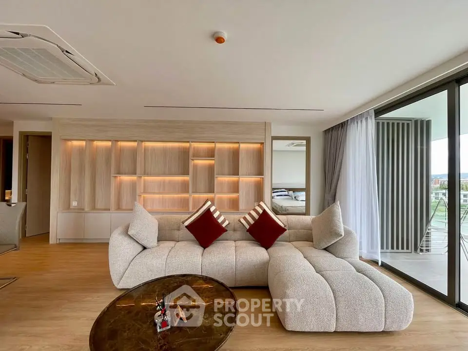 Luxurious modern living room with plush sofa and floor-to-ceiling windows offering stunning views.