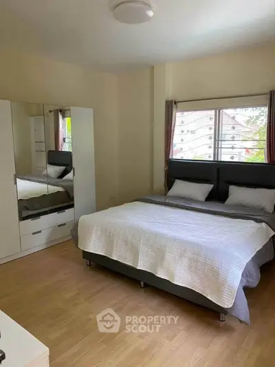 Spacious bedroom with large bed and mirrored wardrobe, perfect for relaxation.