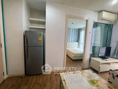 Modern apartment interior with cozy living room and bedroom, featuring wooden flooring and air conditioning.