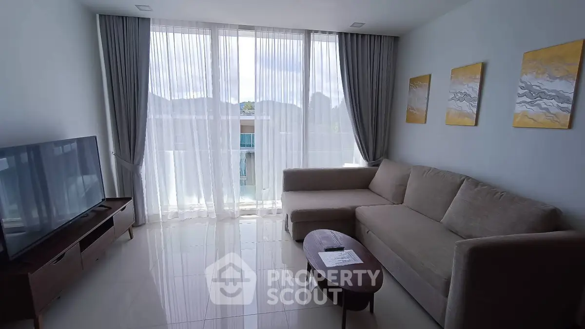 Modern living room with large windows, stylish sofa, and elegant decor in a bright apartment.