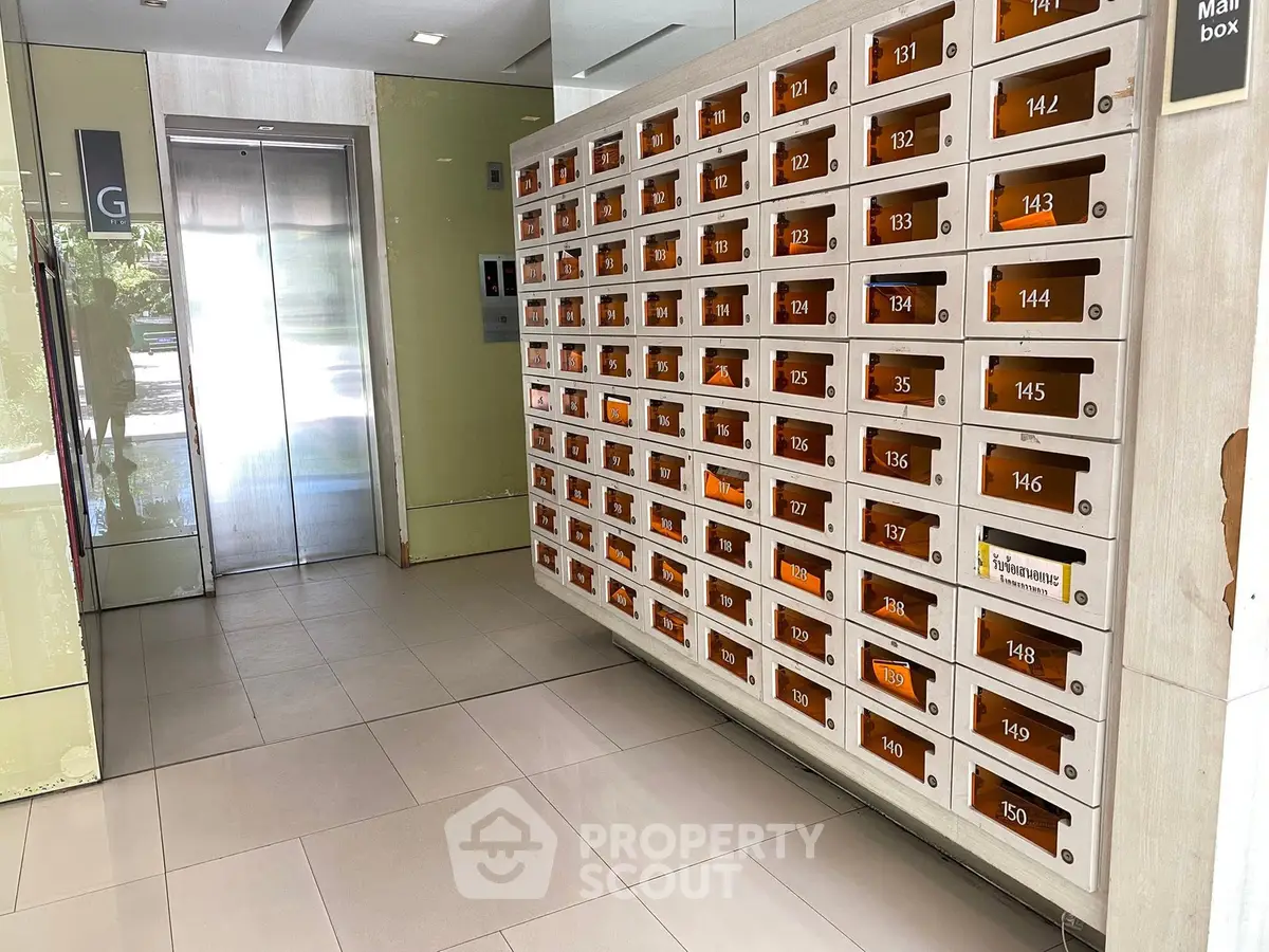 Modern apartment building lobby with mailboxes and elevator access.
